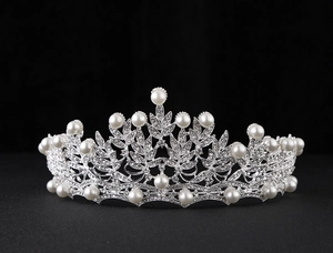 Detailed view of silver bridal crown featuring delicate rhinestones and white pearls
