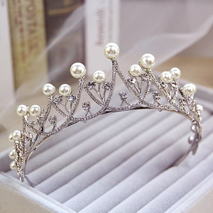 Detailed close-up of a silver bridal tiara with sparkling rhinestones and white pearls