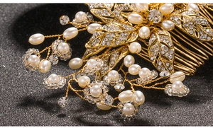Detailed close-up of golden leaf bridal hair comb with pearls and sparkling crystals