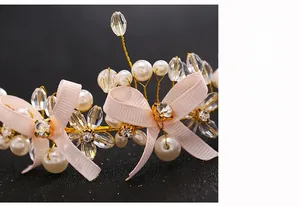 Close-up of bridal headband with crystals, faux pearls, and pink ribbon bow