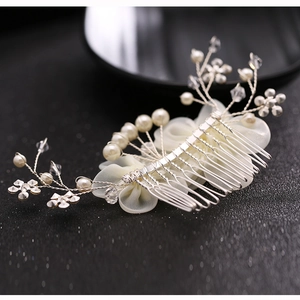 Detail of bridal hair comb with white chiffon flowers, pearls and crystals on silver base