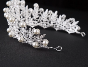 Detailed macro shot of silver bridal crown featuring brilliant rhinestones and white pearls