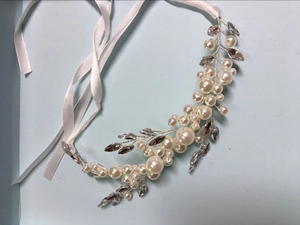Detail of bridal hair vine with pearls and crystals featuring white satin ribbons for closure