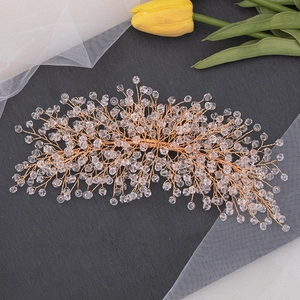 Macro detail of handmade bridal hair comb with golden wires and clear crystals