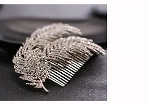 Macro shot of silver bridal hair comb with feather design and sparkling rhinestones