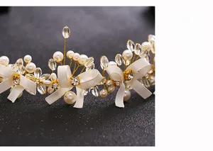 Detail of bridal hairband with handmade crystal beads, white ribbon bow and pearls