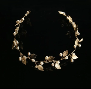 Detailed view of handmade gold bridal headband with metallic leaves and white pearls
