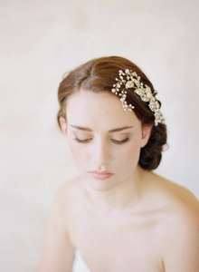 Detail of handmade bridal hair comb featuring golden leaves with pearls and crystals