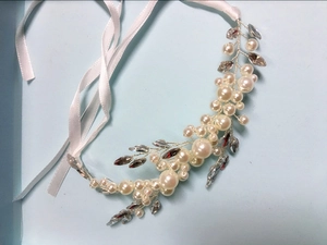 Detail of handcrafted bridal hair vine with pearls, rhinestones, and white satin ribbons