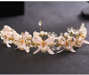 Detailed macro view of handmade bridal headband with crystals, pearls and pink bows