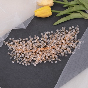 Close-up of handmade bridal hair comb with gold wires and sparkling crystals