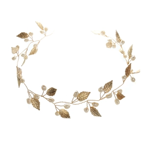 Detailed macro shot of handmade golden bridal headband with pearls and leaf accents
