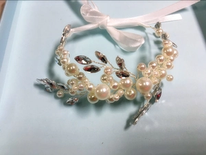 Detailed macro view of handmade pearl bridal headband with crystals and white ribbons