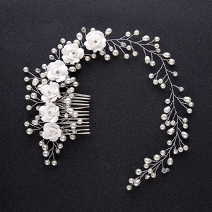 Detailed close-up of bridal headband featuring white handmade roses, pearls, and crystals