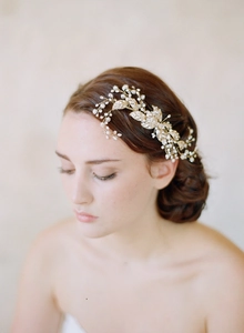 Detail of bridal hair comb with golden leaves, pearls and crystals on model hair