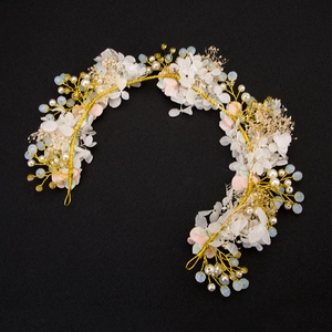 Detail of bridal headband with gold wire, white flowers, pearls and light blue beads