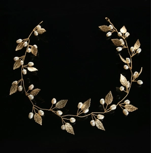 Detail of handmade bridal gold vine headband with metallic leaves and white pearls