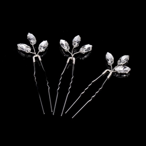 Detail view of three silver leaf bridal hair pins with marquise cut crystals on black background