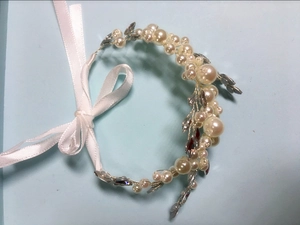 Detail of handcrafted bridal headband with pearls, rhinestones and white satin ribbon
