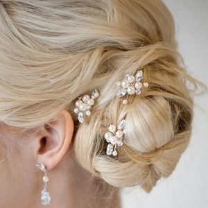 Elegant bridal pearl hairpins and matching earrings set on blonde braided hairstyle