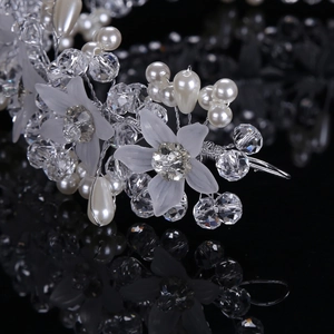 Elegant bridal headband with handmade white flowers, pearls, and crystals on a black background