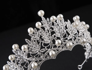 Macro view of bridal crown detailing silver base with inlaid pearls and sparkling rhinestones