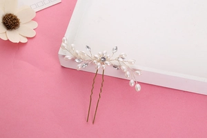 Détail de l'épingle à cheveux de mariée vintage dorée avec perles blanches et strass