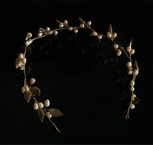 Detailed view of handcrafted bridal headband with gold metal leaves and white pearls