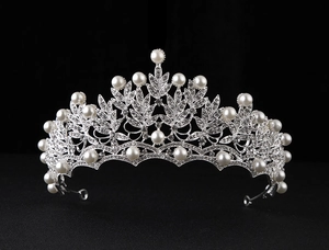 Detailed view of bridal crown with silver leaf design, white pearls and sparkling rhinestones