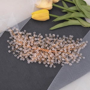 Detail of rose gold bridal hair comb with handmade crystal beads on stone surface