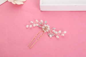 Détail macro d'épingle à cheveux de mariée avec perles blanches et feuilles dorées