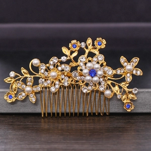 Detail of bridal hair comb with gold floral design, white pearls and blue gemstones