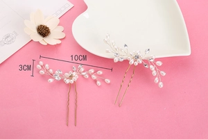Détail des épingles à cheveux de mariée dorées avec perles blanches et cristaux
