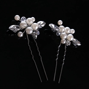 Close-up of pearl and rhinestone flower clusters on U-shaped silver bridal hair pins