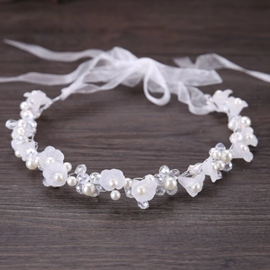 Détail d'un bandeau de mariée avec fleurs blanches, perles et perles de cristal sur bois