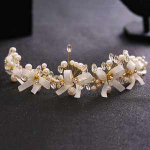 Elegant bridal headband with handmade pearls, crystals, and ribbon on a gold wire base