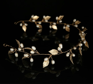 Detail of handmade gold bridal headband with metallic leaves and white pearls