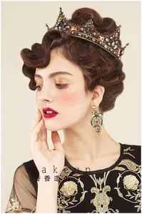 Detail of vintage Baroque metal crown and ethnic earrings with amber gemstones