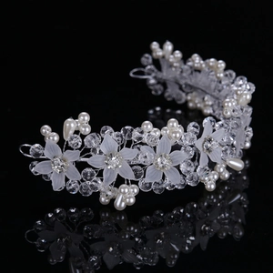 Detail of silver bridal hair vine with white flowers, crystals, and pearls on black