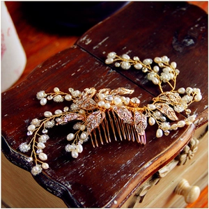 Detailed view of handmade bridal hair comb with gold leaves, pearls and rhinestones