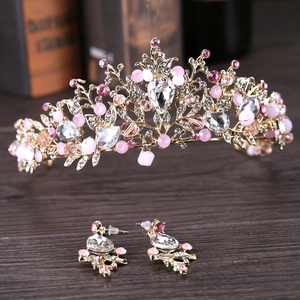 Detalle de la corona de cristal rosa y pendientes a juego con base dorada de hojas