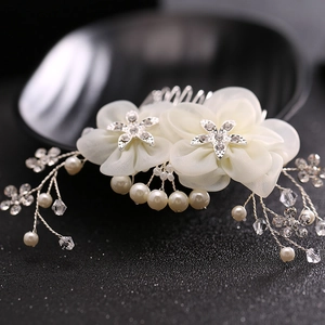 Exquisite bridal hair comb with silk flowers, rhinestones, and pearls on a dark base