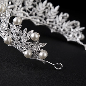 Elegant silver bridal crown with white pearls and sparkling rhinestones on black background