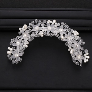 Detailed close-up of handmade bridal headband with crystal flowers and white pearls