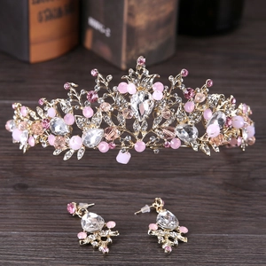 Detalle de un conjunto de joyas de novia doradas con cristales rosas y corona floral