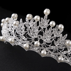Elegant silver bridal tiara with sparkling rhinestones and white pearls on black background
