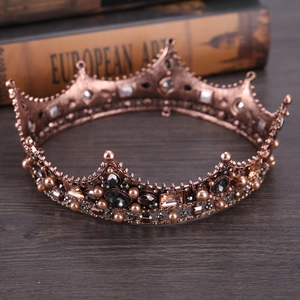 Detail of baroque crown with black crystals and brown pearls on vintage wood surface