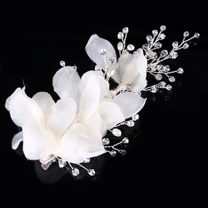 Detail of bridal hair clip with white fabric flowers, crystals and pearls on silver wire