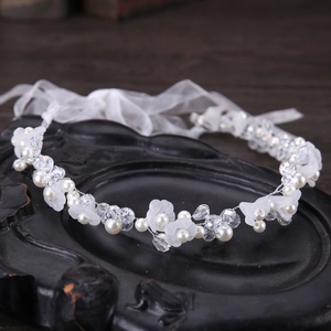 Détail du bandeau de mariée avec fleurs en résine blanche, perles et fil d'argent