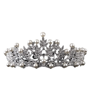 Elegant silver bridal crown with white pearls and sparkling rhinestones on white background